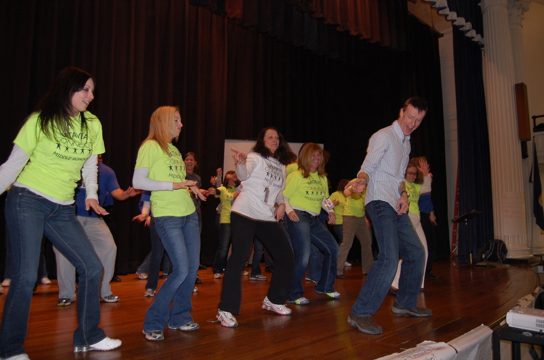 Andy dancing on stage with conference advisors